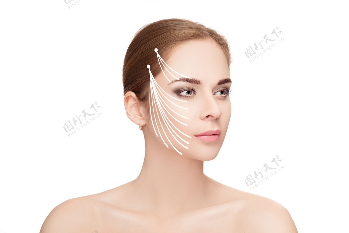 面容水疗肖像迷人的女人与箭头在她的脸上白色背景面举起概念塑料手术治疗 药物医药女人提拉