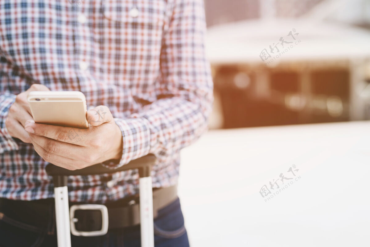 连接年轻的商人穿格子呢衬衫关闭直接在手机上使用电话站着在移动智能手机上观看信息电话.soft集中技术无线移动