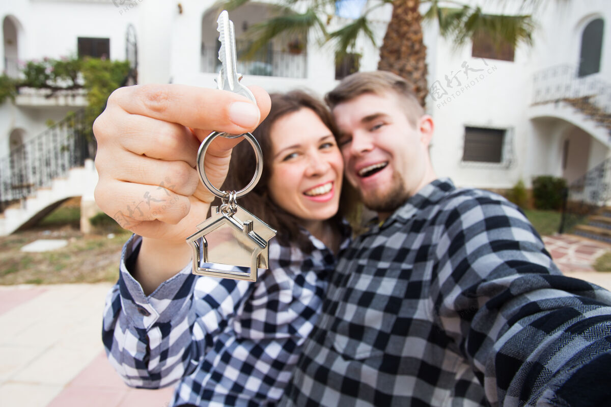 房产物业 房地产和公寓概念-快乐有趣的年轻夫妇展示他们的新钥匙不动产开始抵押