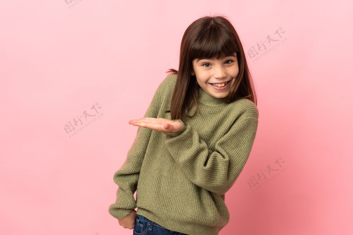指着小女孩孤立在粉红色的背景提出一个想法 同时看着微笑的方向女孩产品小