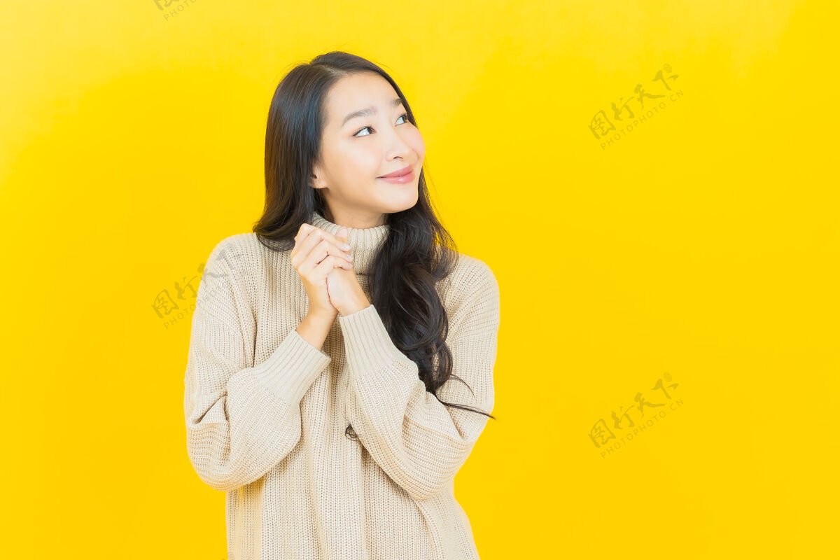 亚洲人美丽的亚洲年轻女子在黄色的墙上微笑快乐时髦穿着