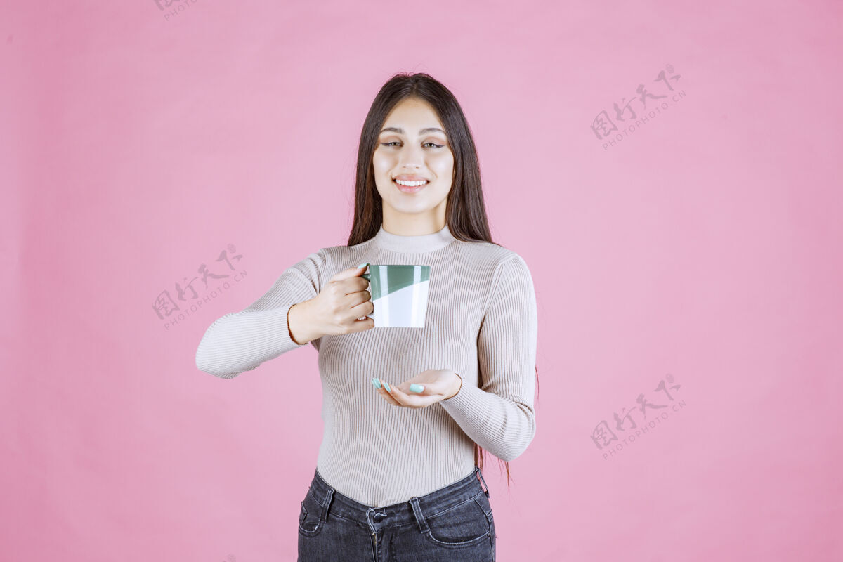 装备女孩拿着一个白绿色的咖啡杯 感觉很积极休闲巧克力能量