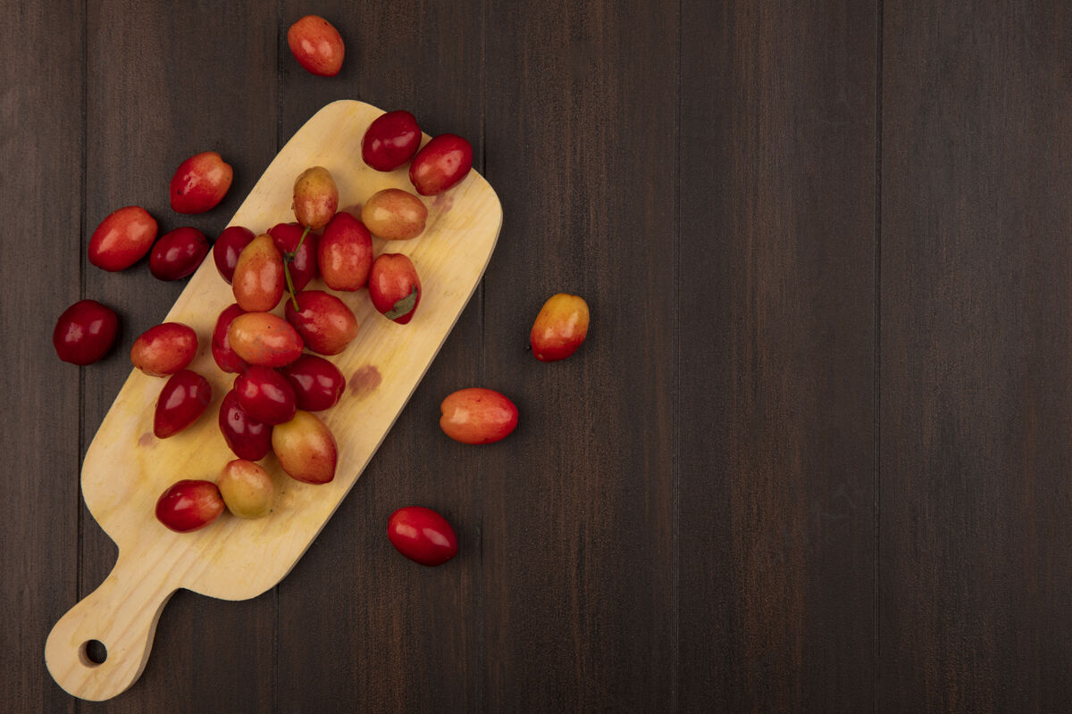 健康小甜挞山茱萸樱桃顶视图在木制厨房板上的木制表面与复制空间配料食物木材