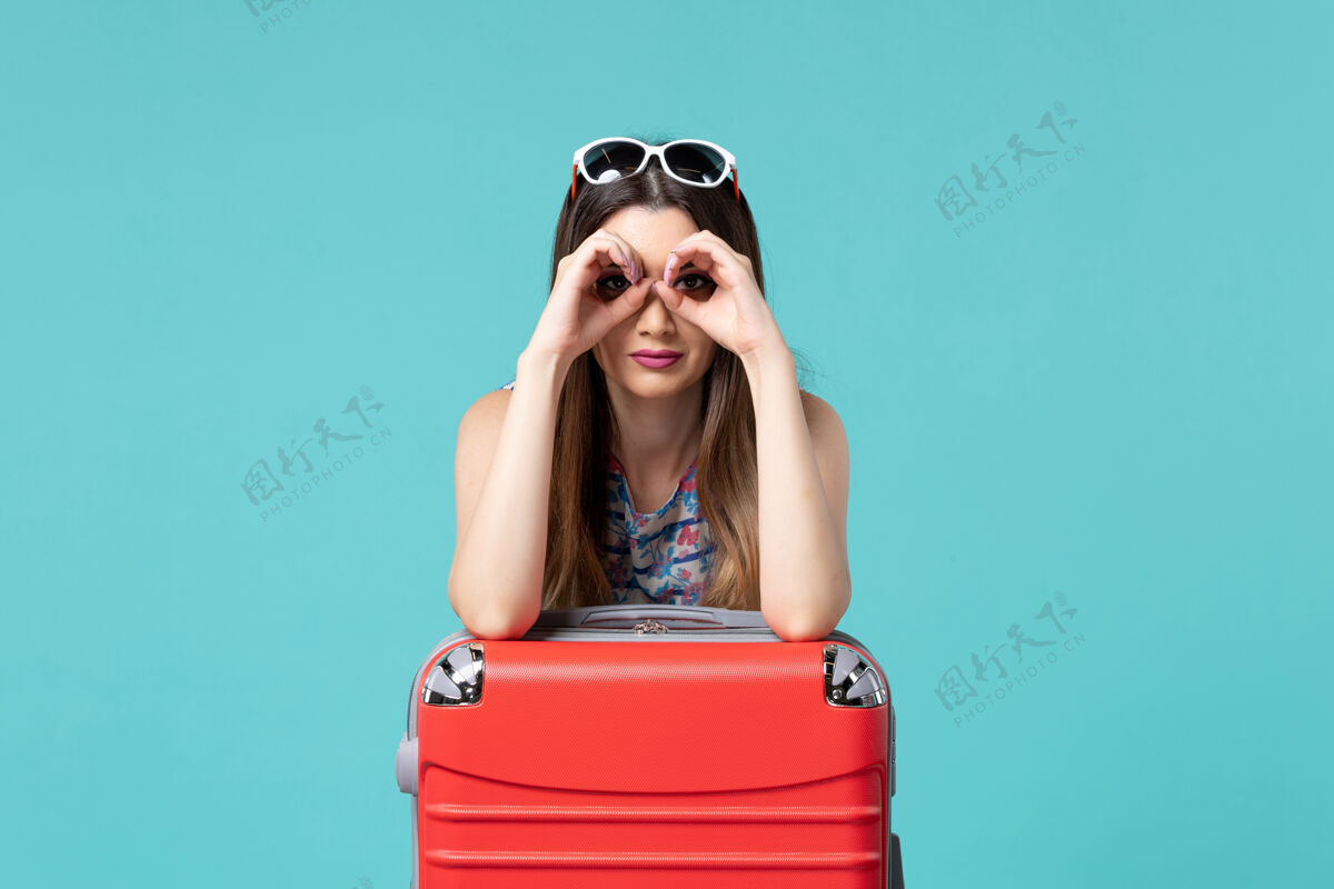 大前景色美丽的女性准备旅行与她的大红色袋子蓝色地板海上度假旅行女孩海美女漂亮