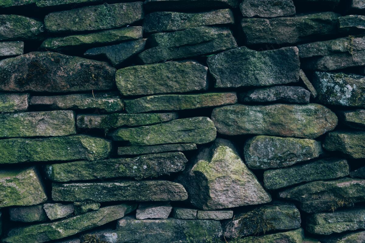 房屋一堵墙的特写镜头 有不同大小和形状的石头花岗岩墙岩石