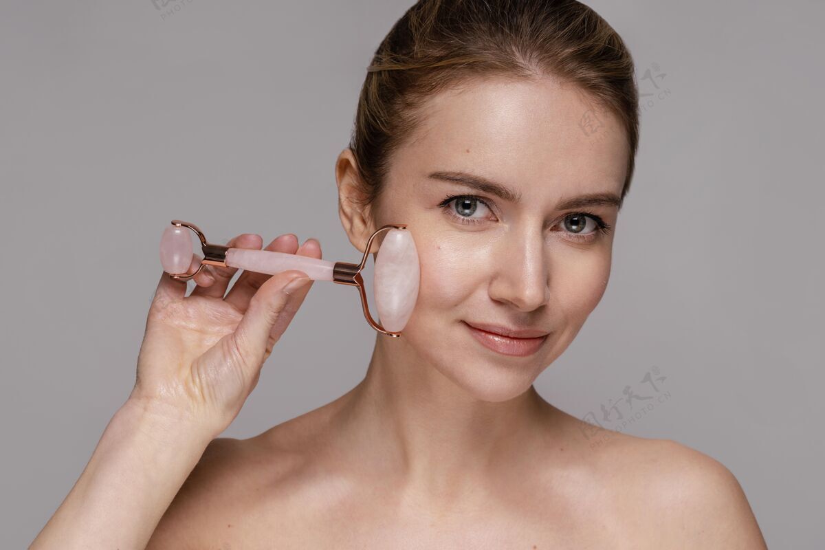 清透肌肤美丽的女人用玉石辊模特化妆品护理