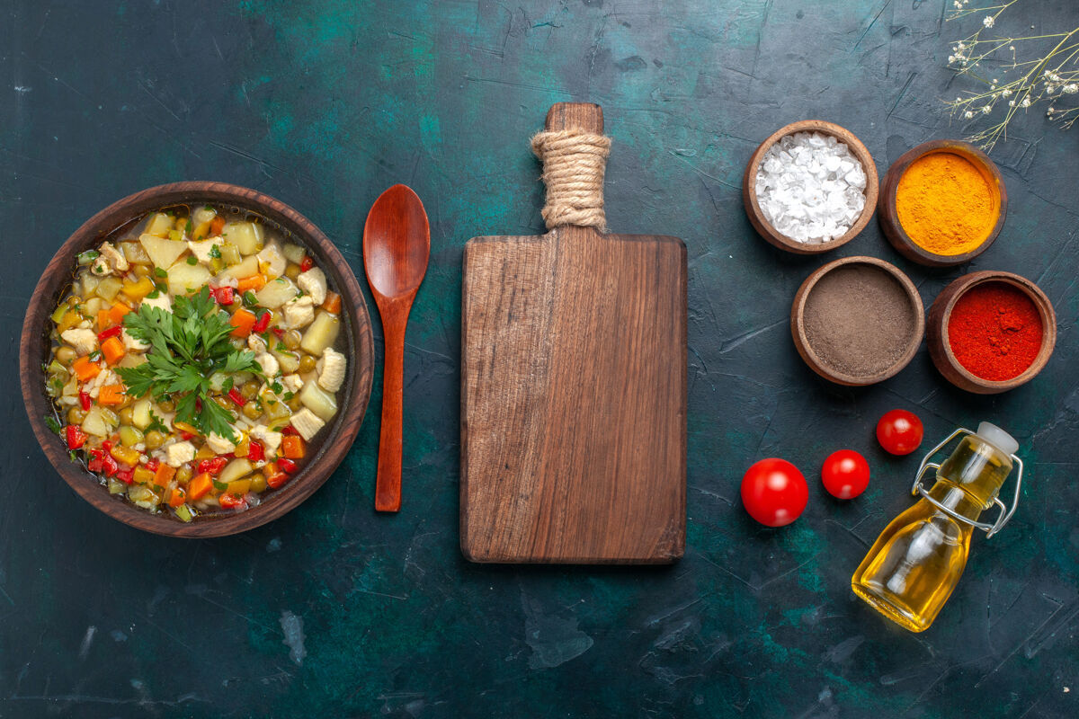 勺子俯瞰美味的蔬菜汤与油和不同的调味品对黑暗的桌子配料蔬菜汤色拉油沙拉油漆顶部
