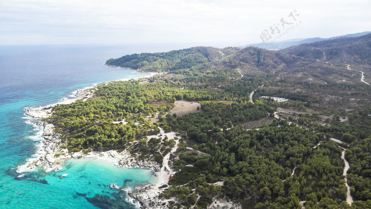 镁砂爱琴海沿岸有蓝色透明的海水 周围绿树成荫 岩石 灌木丛和树木 从无人机希腊俯瞰希腊地中海欧罗巴
