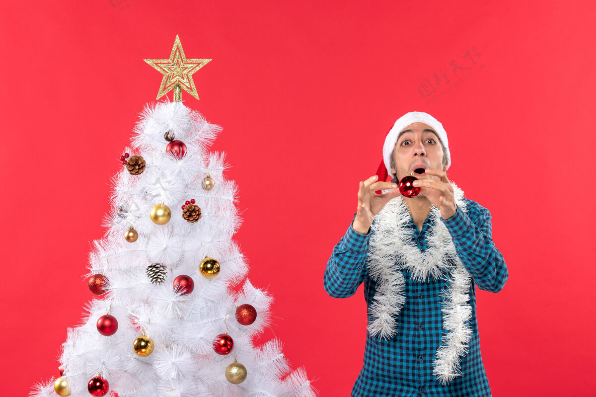 庆祝一个戴着圣诞老人帽 穿着蓝色条纹衬衫 满脸笑容 情绪激动 很有趣的年轻人配件衣服脱光