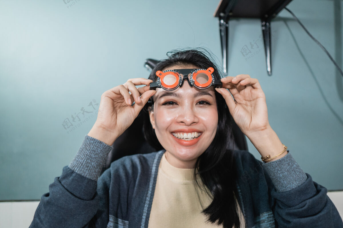 女人一位美丽的女士拿着正在眼科诊所房间里使用的测量眼镜摆姿势病人专业眼镜