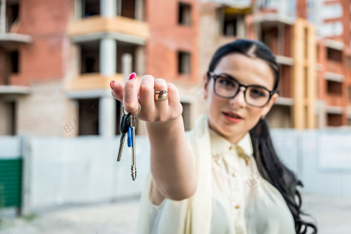 提供选择重点放在女性手与钥匙从新公寓钥匙工人房地产