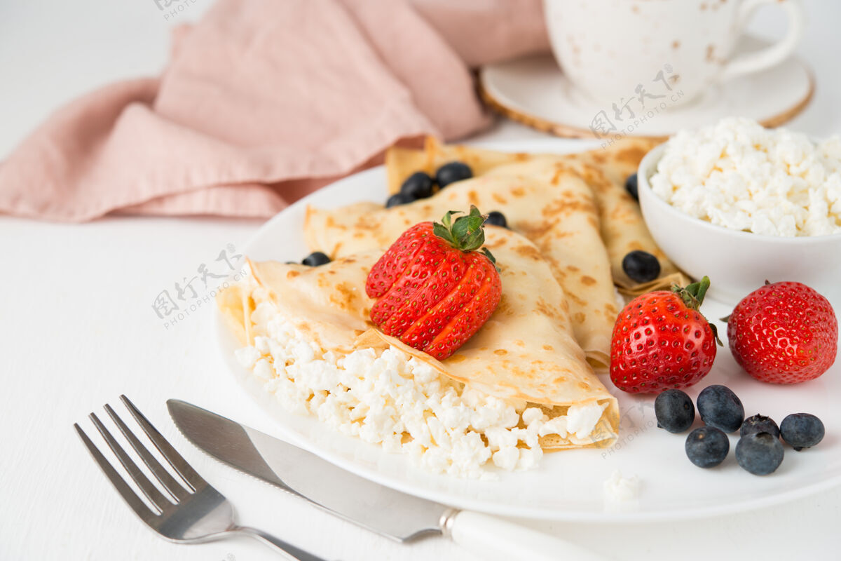 金色传统的俄罗斯薄饼与白干酪和浆果在一个盘子里 选择性的重点 复制空间早晨午餐法国