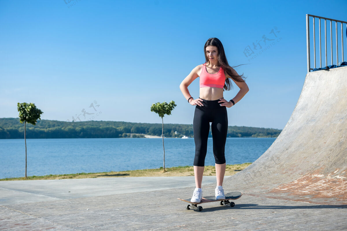 休闲十几岁的女孩骑着滑板健康的生活方式青少年天空骑行