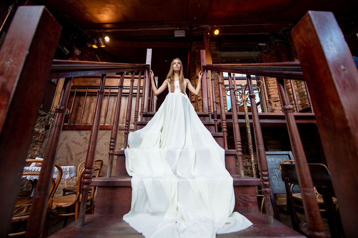 人穿着白色飘逸长裙的年轻优雅女孩在室内楼梯上摆姿势女人优雅模型