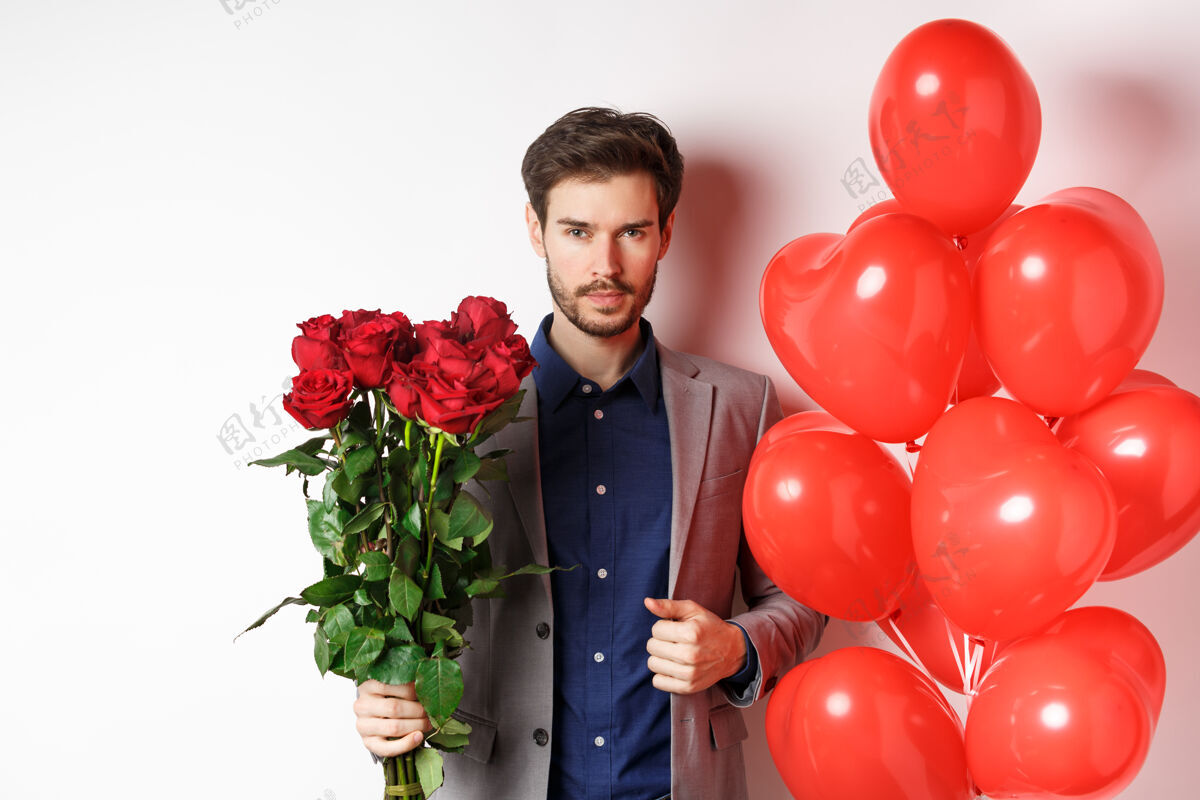 伴侣情人节帅气自信的男人穿着西装去约会 手里拿着一束红玫瑰和心形气球 拿着礼物站在白色背景上送给爱人男人日子关系