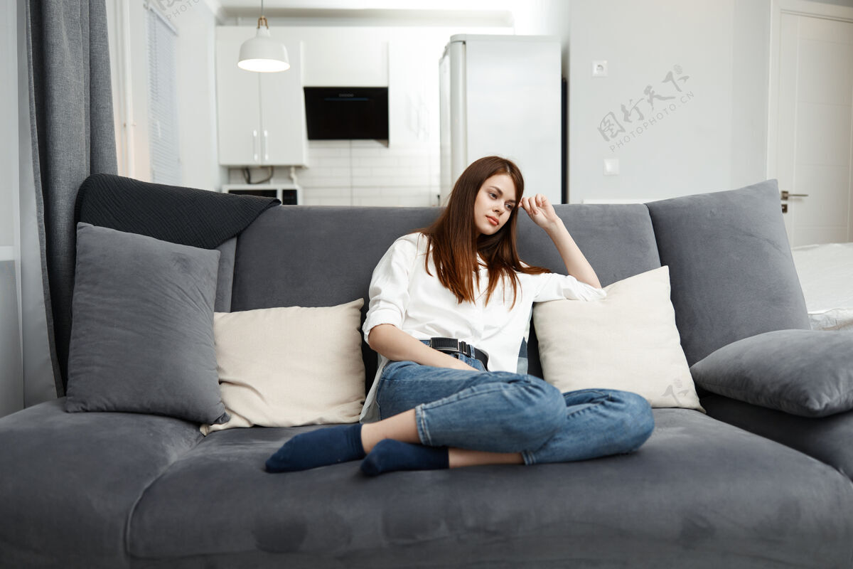 救济女人在闲暇时间躺在家里的沙发上休息坐着生活方式呼吸