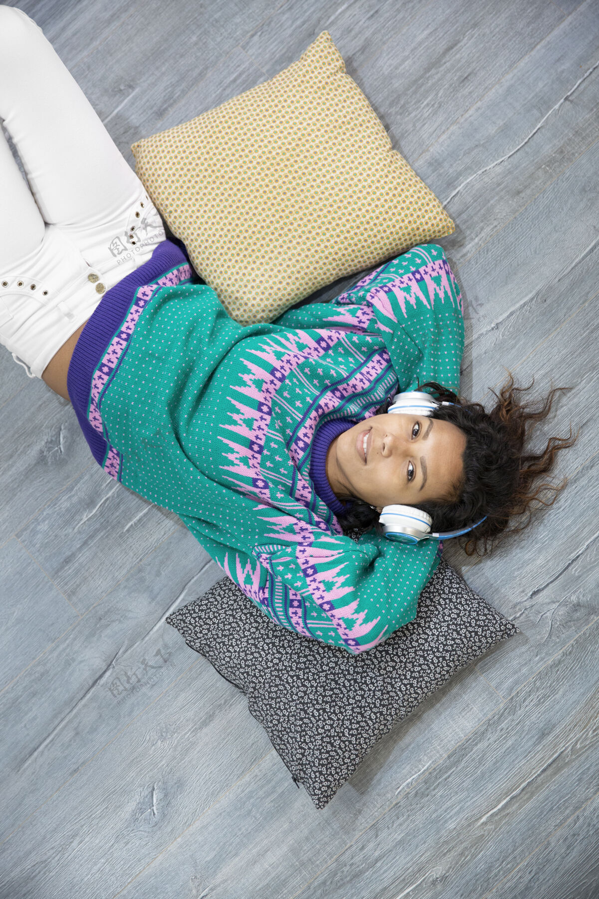 酷放松的黑发女孩躺在家里的地板上听音乐文本空间肖像女孩室内