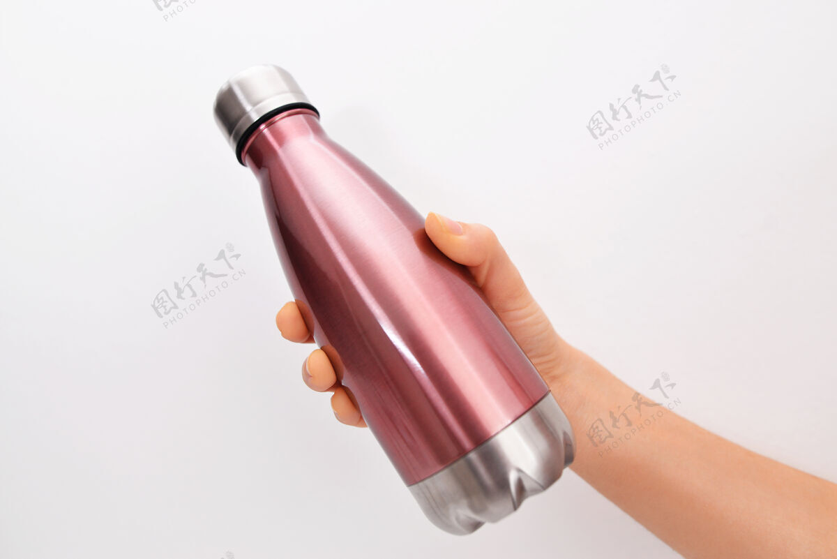 铝女性手的特写 拿着可重复使用的不锈钢环保热水瓶 在白色的墙上不含塑料零浪费烧瓶男人户外
