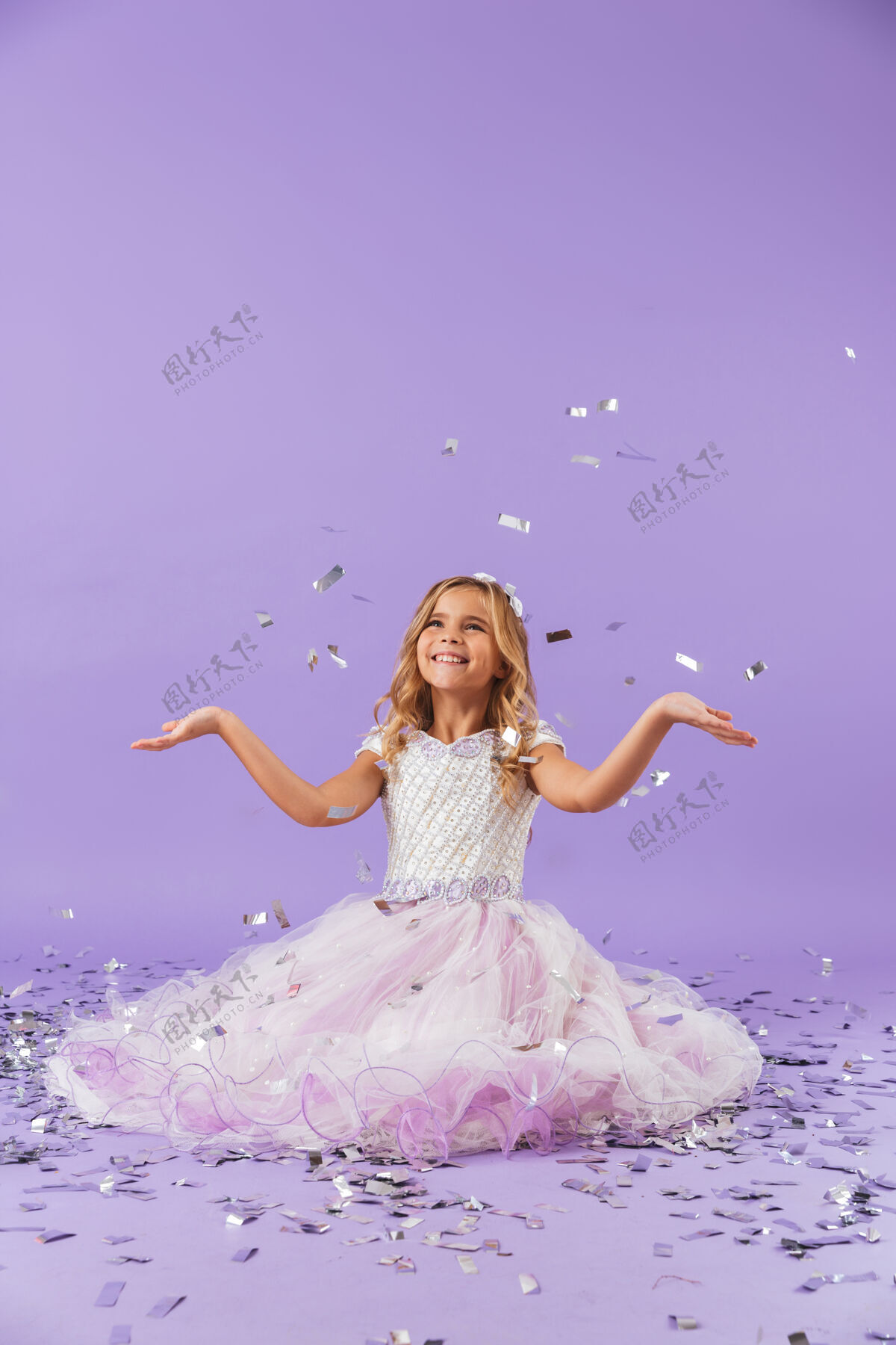 女儿穿着公主裙的漂亮小女孩孤零零地坐在紫罗兰色的墙上小年轻连衣裙