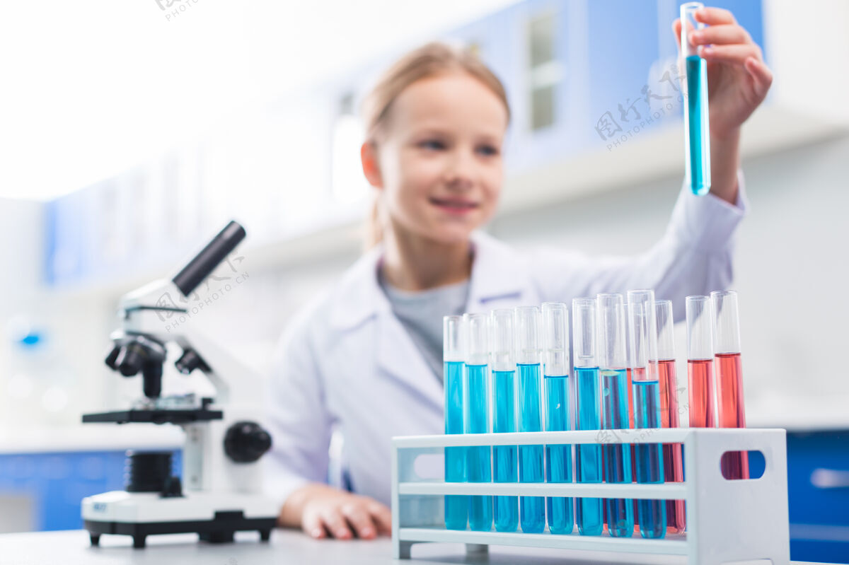 生物学蓝色试剂选择性焦点玻璃小透明瓶放在立场上 放置在表面时 女孩摆在背景上女孩专业知识进度