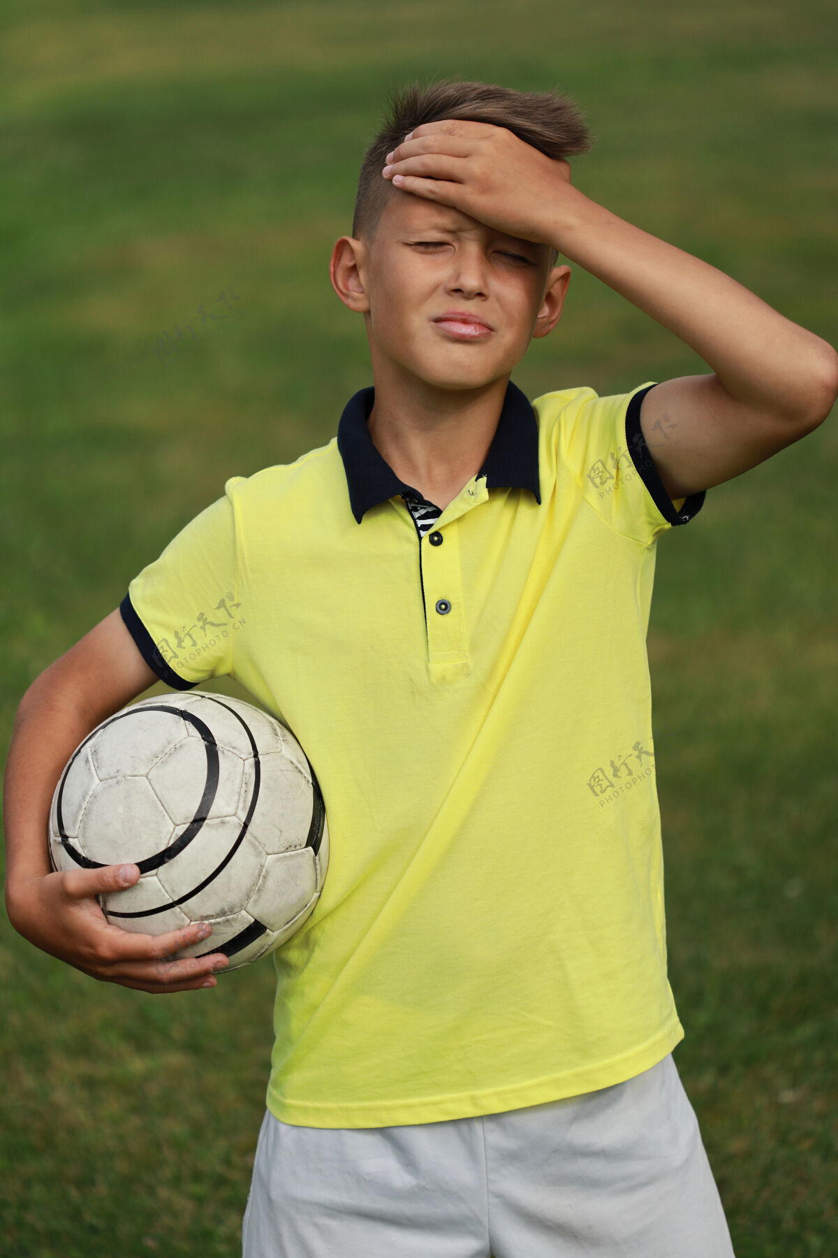 活跃穿着黄色t恤的帅哥足球运动员站在足球场上 手里拿着一个球运动年轻欧洲