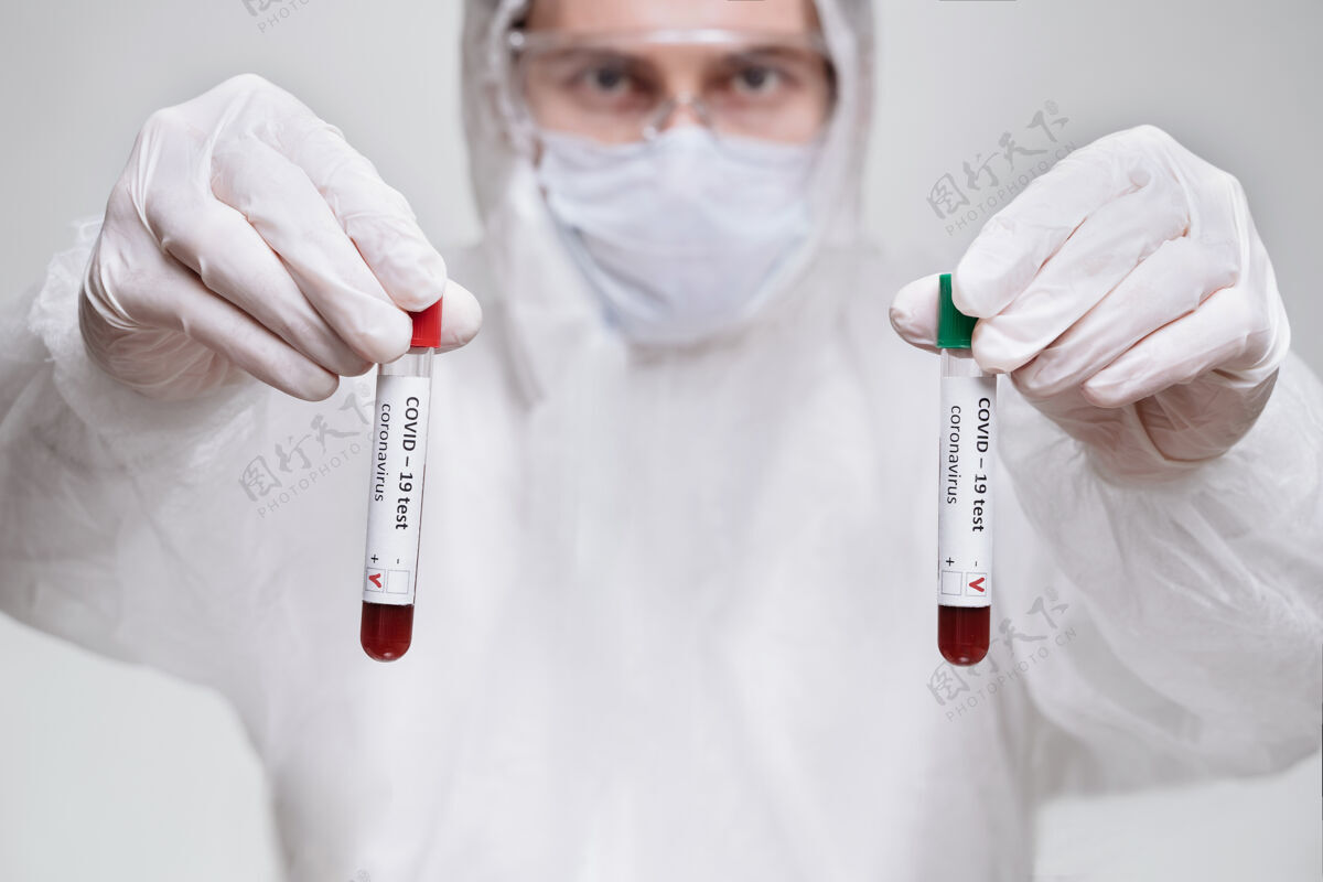 医生穿着生物危害防护服的实验室助理拿着两份实验室血样实验室测试外套