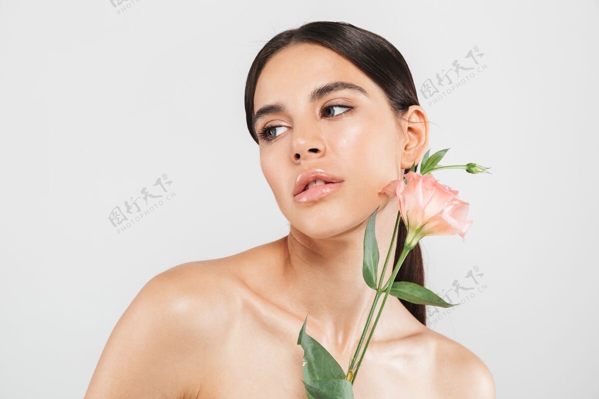 新鲜美丽的肖像一个迷人的感官健康的女人站在隔离的白色墙壁 摆出一朵花纯洁女性肖像
