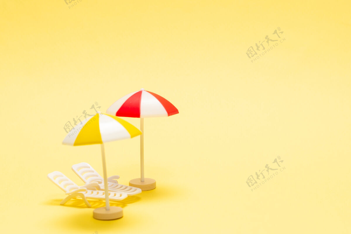 图形两个日光浴者和一把黄色背景的红伞复制空间蜜月温暖生活