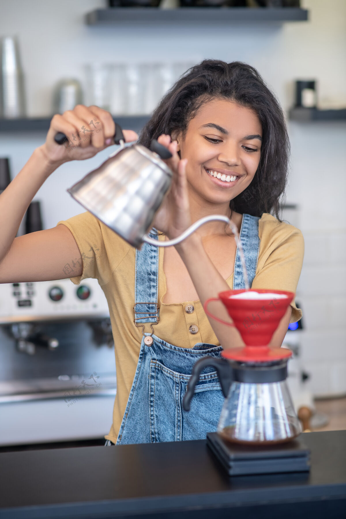 暗黑头发过滤酿造微笑的方法年轻漂亮的女人在咖啡店用pourver煮咖啡方法焦点成功