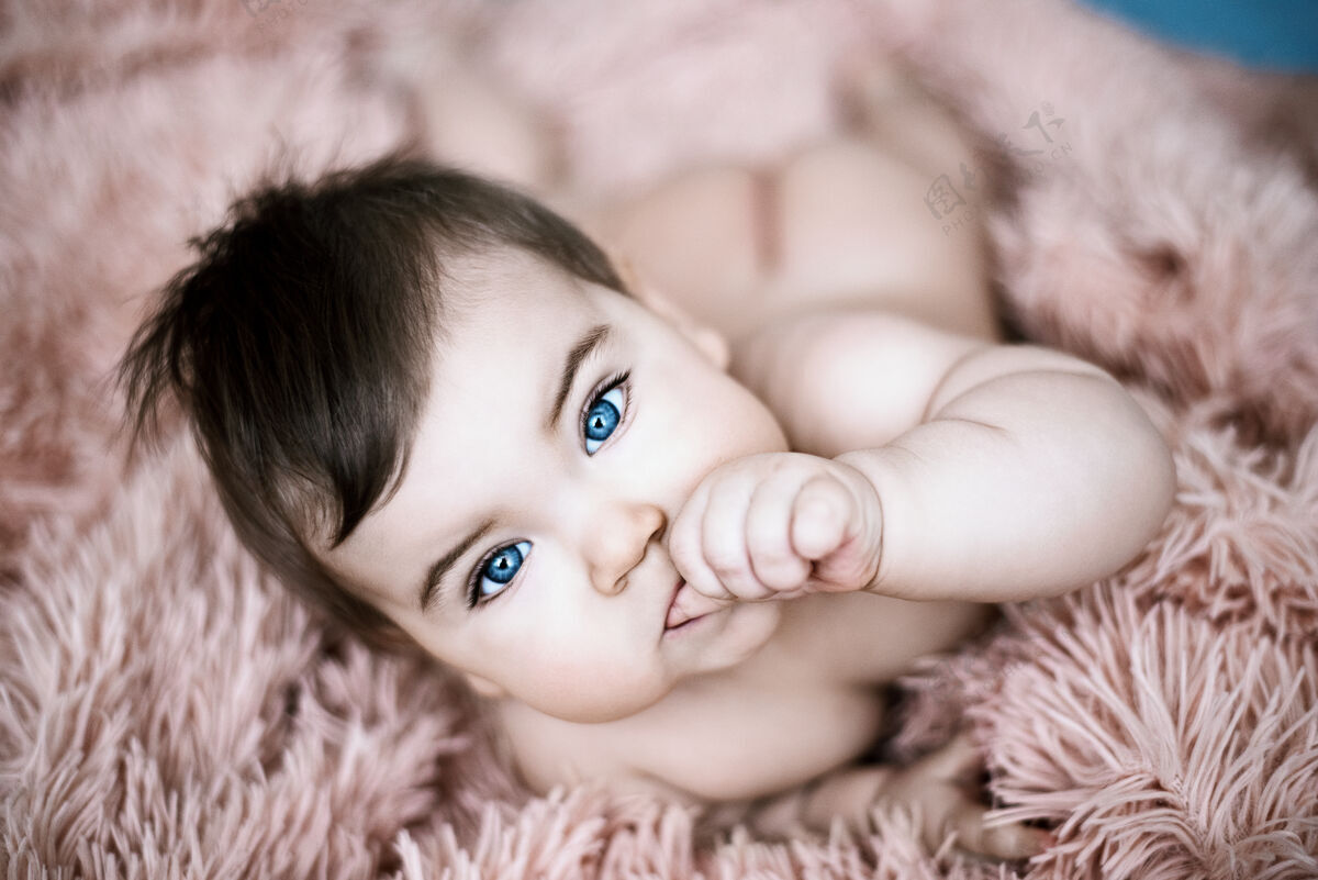 可爱特写美丽的蓝眼睛小宝宝躺在床上 毛绒绒的毯子男孩甜蜜幼儿