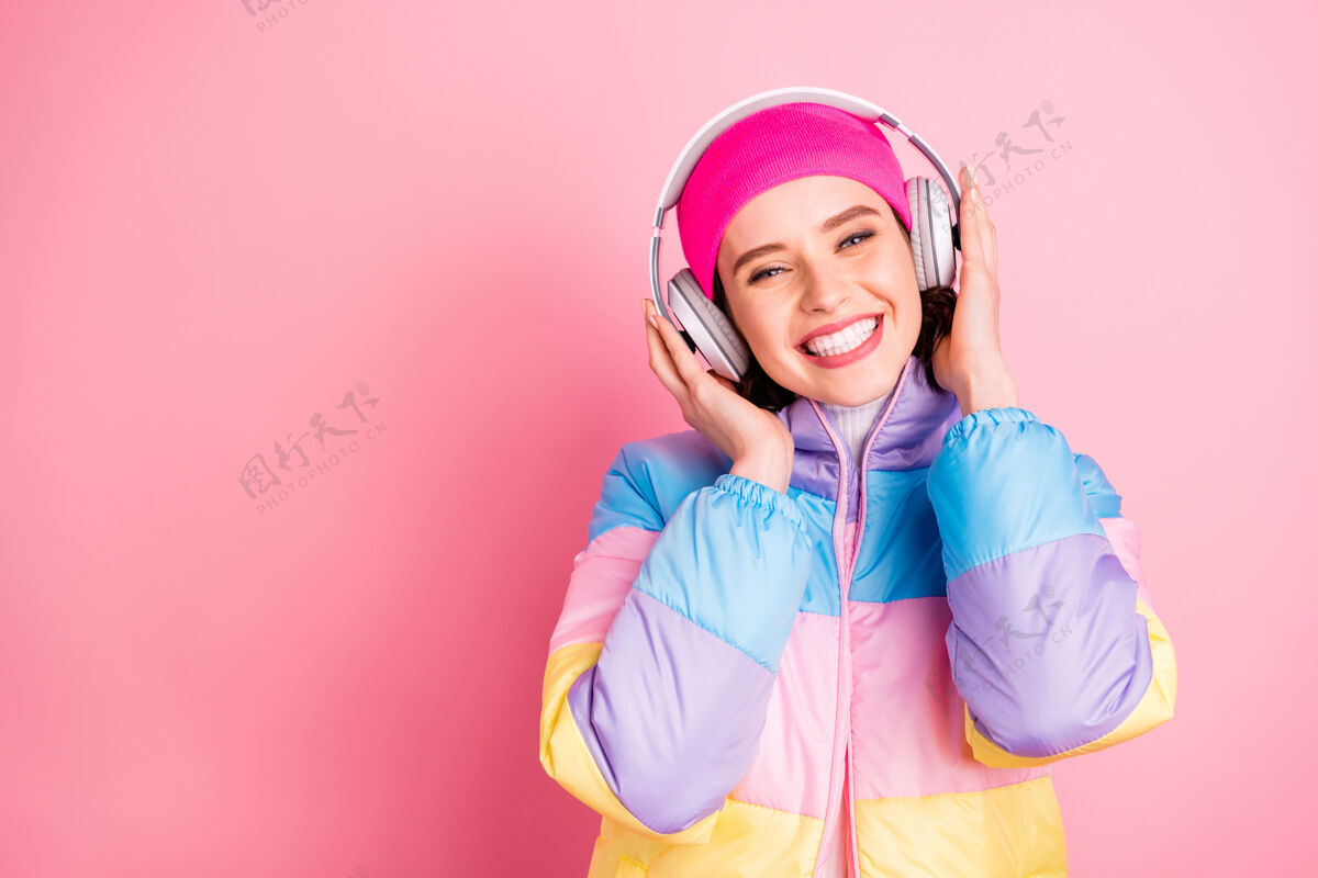 享受她美丽迷人可爱开朗快乐的女孩享受新的浪漫音乐mp3音频隔离粉红色粉彩背景特写肖像流行耳机女人