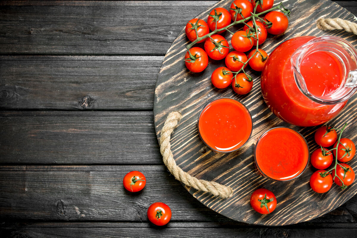 液体番茄汁放在罐子里 玻璃杯放在黑色木桌上的托盘上木头生的刷新