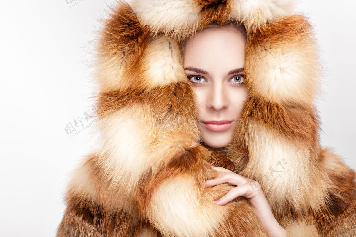 外套身着豪华狐皮的年轻金发美女肖像大衣.冬天灰色背景时尚肖像性感模型