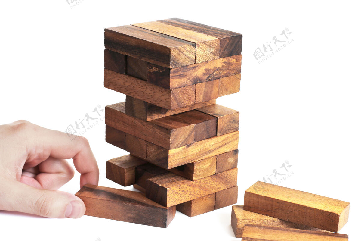 做生意一个白色的游戏背景.娱乐!商业 抽象 木头 手 人 孩子 游戏 建筑 坠落 成功 砖块 游戏 玩具 建筑 竞争 危险 塔 结构 块 概念 风险 对象 堆栈 堆 选择 放置 隐喻 简加
