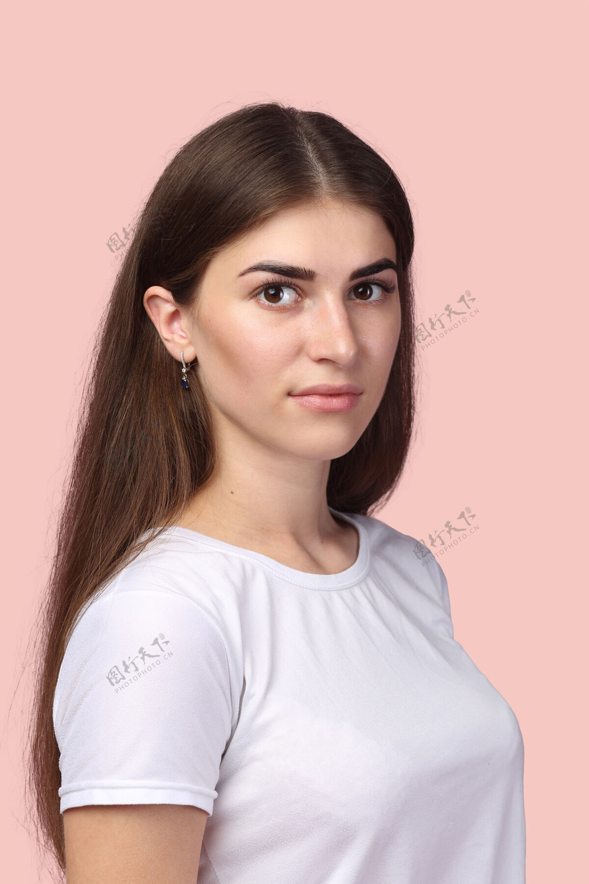 姿势长发的漂亮女孩 穿着白色t恤 摆出淡粉色的姿势背景可爱深色头发 看起来很成功 很专业 对生活有积极的态度青少年充分舒适