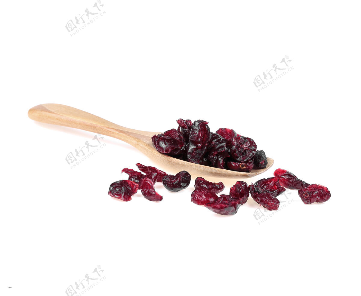食物干蔓越莓放在木勺上隔离在白色水果宏堆