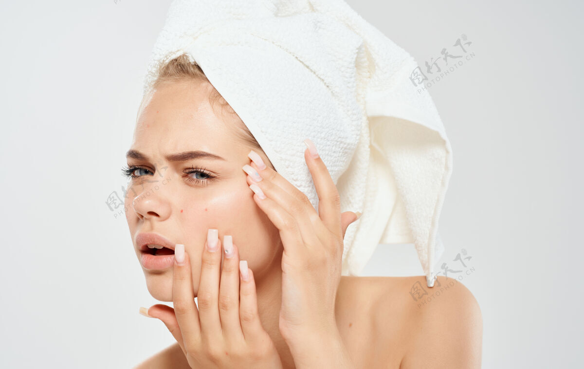 皮肤护理一个女人头上带着毛巾挤出脸上的青春痘问题皮肤美容皮肤科女士健康面部
