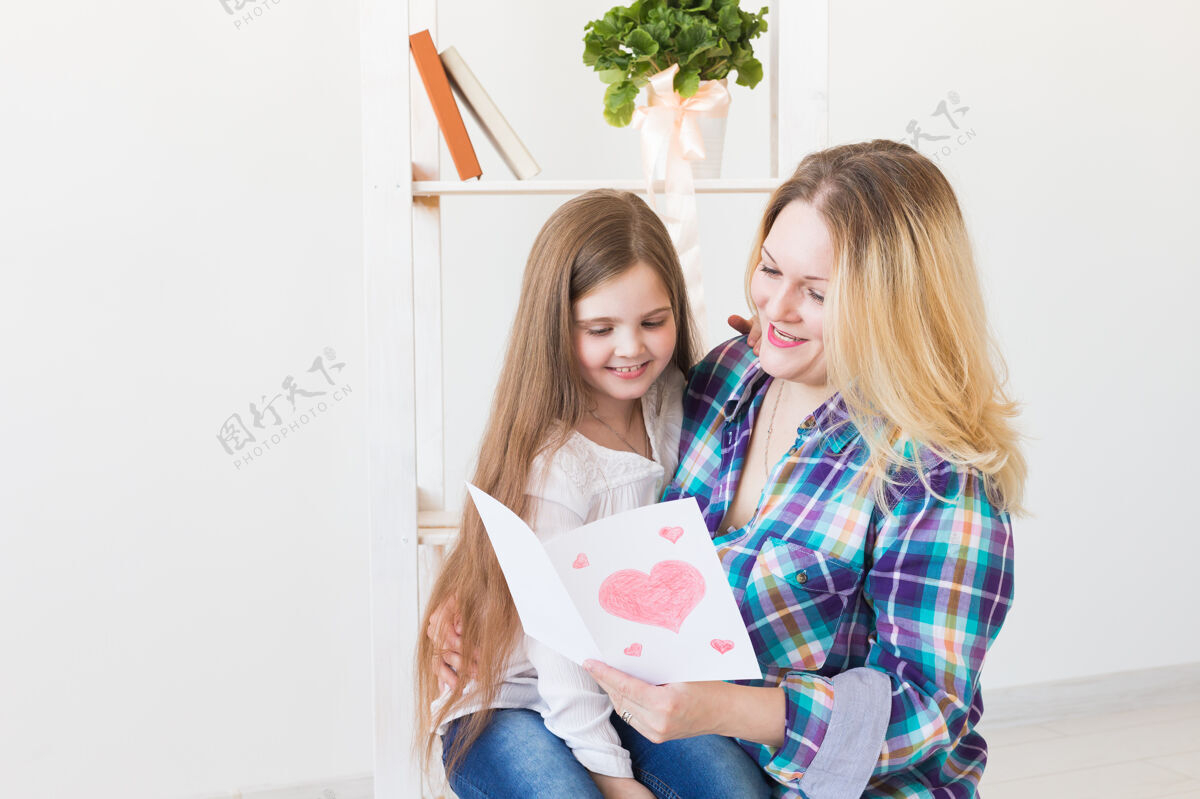 童年母亲节快乐白天孩子女儿向妈妈祝贺 并给她明信片妈妈还有小女孩父母妈妈女儿