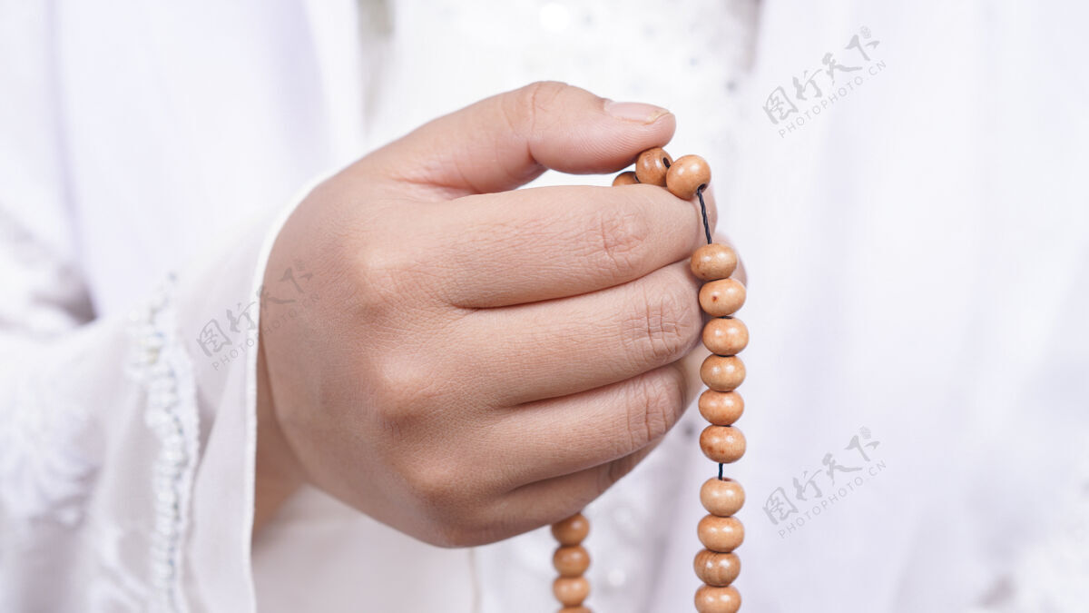 礼拜戴着念珠的亚洲穆斯林妇女与白色塔斯比祈祷书籍手位置