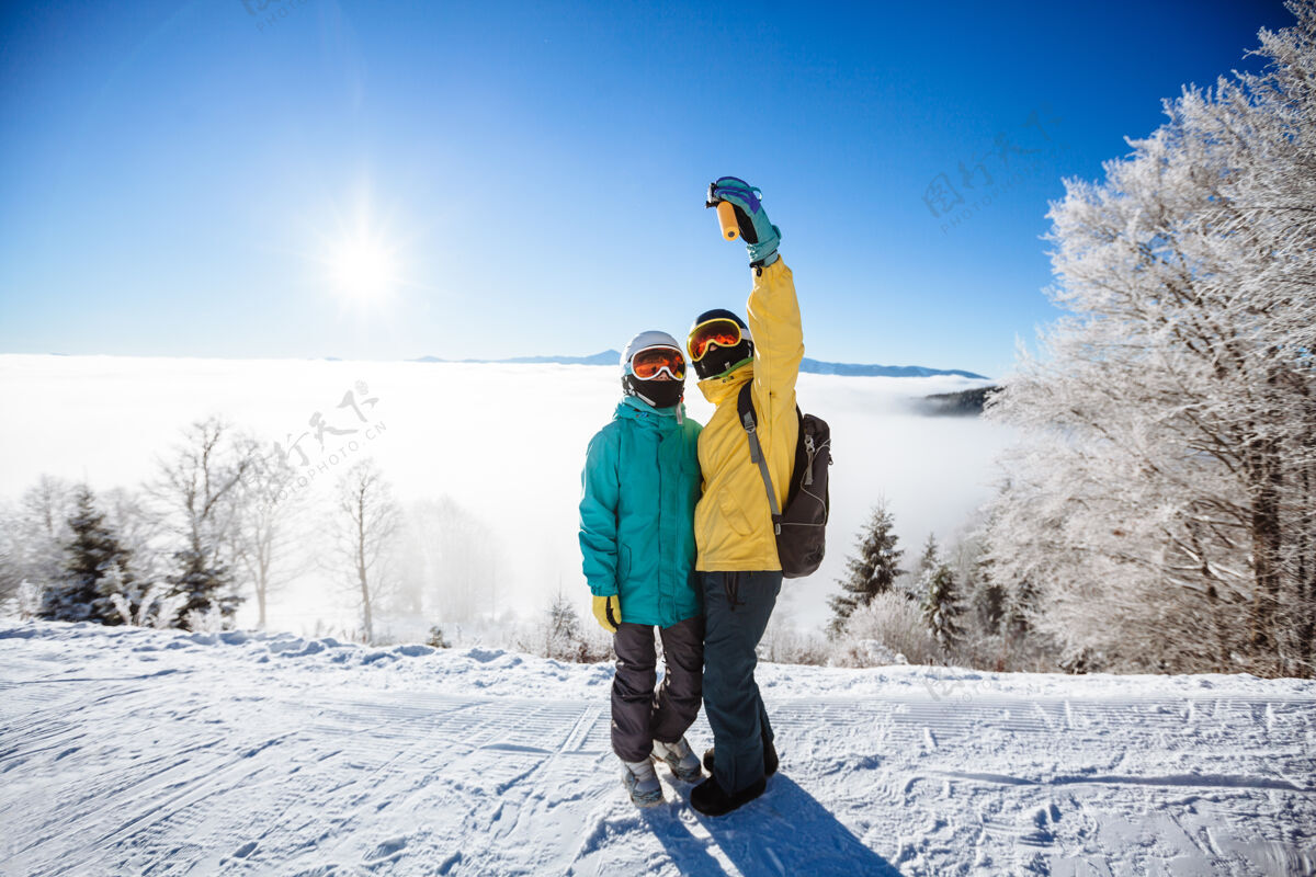 山滑雪者在山上用智能手机拍照站立自然假期