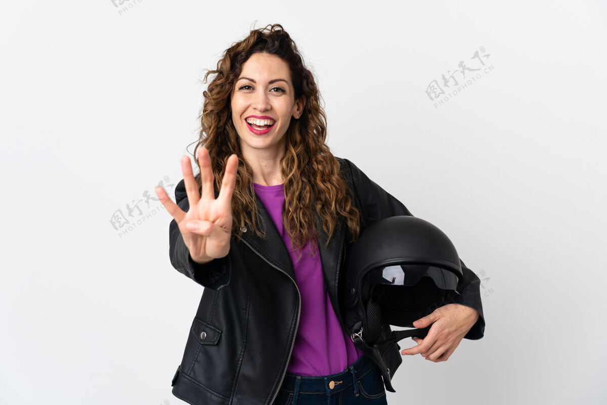 墙年轻的高加索女子手持摩托车头盔高兴地用手指数着四个黑发摩托车手驾驶