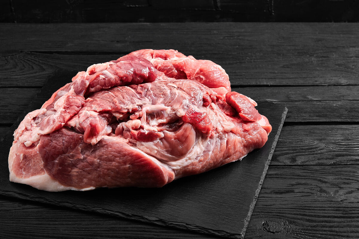 食物新鲜的猪里脊肉放在灰色背景的石板板上 配上蔬菜 供杂货店使用猪肉肉新鲜