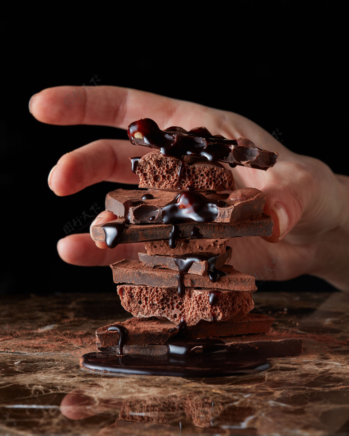 巧克力女的手拿着一块巧克力 孤立的就黑了诱惑碎部分