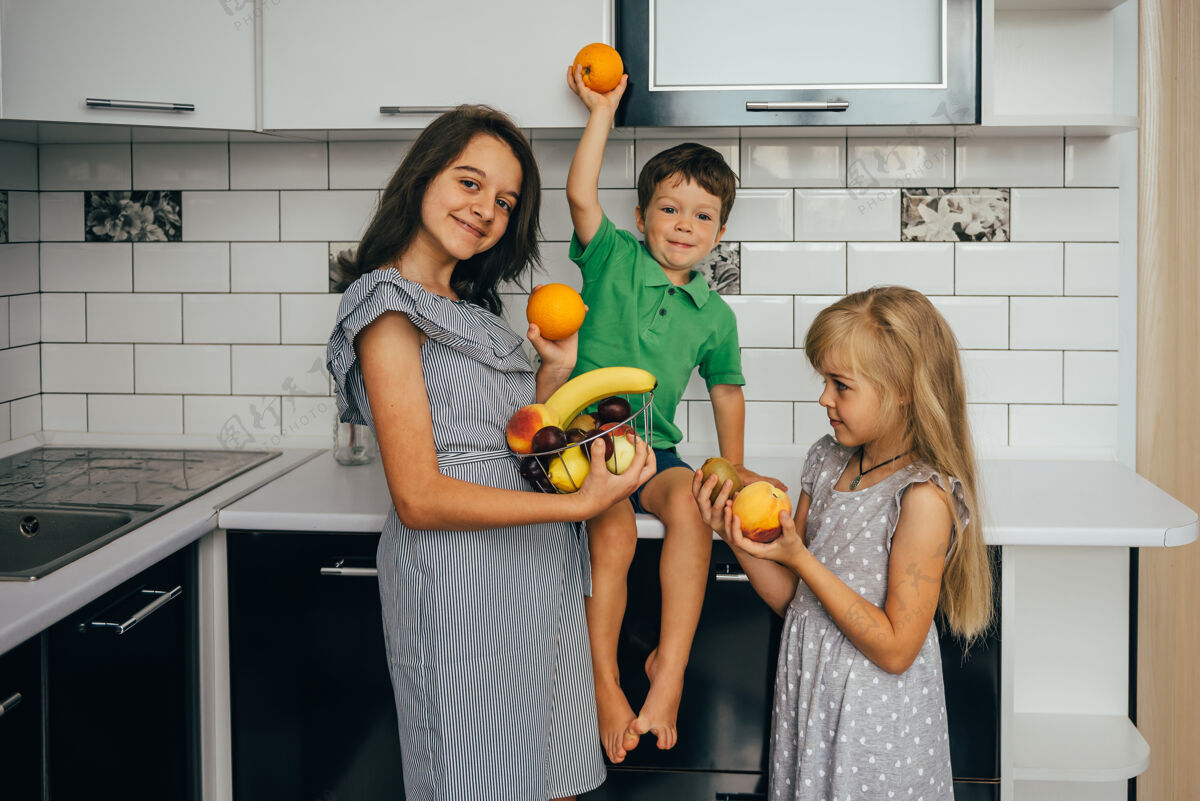 水果健康的概念吃有趣孩子们在厨房里吃水果家庭房子女性