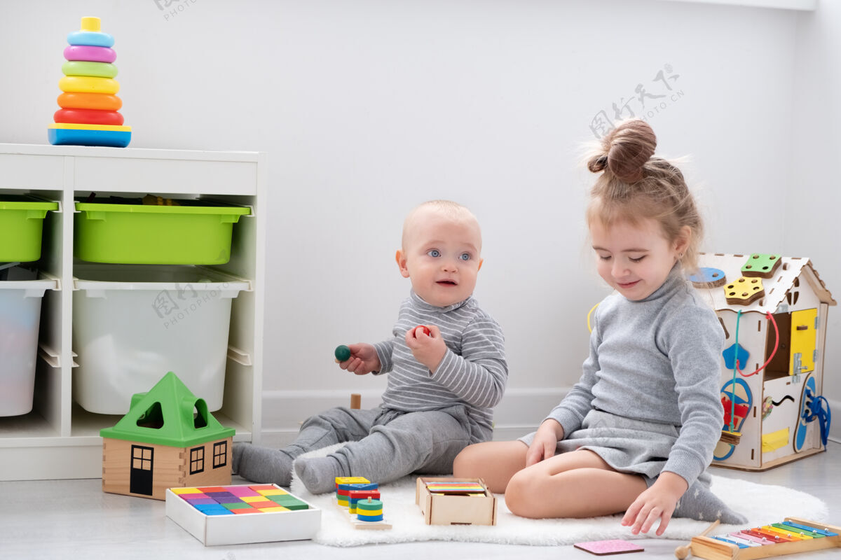 婴儿小男孩和姐姐玩木头玩具玩具早儿童发展游戏忙碌玩具