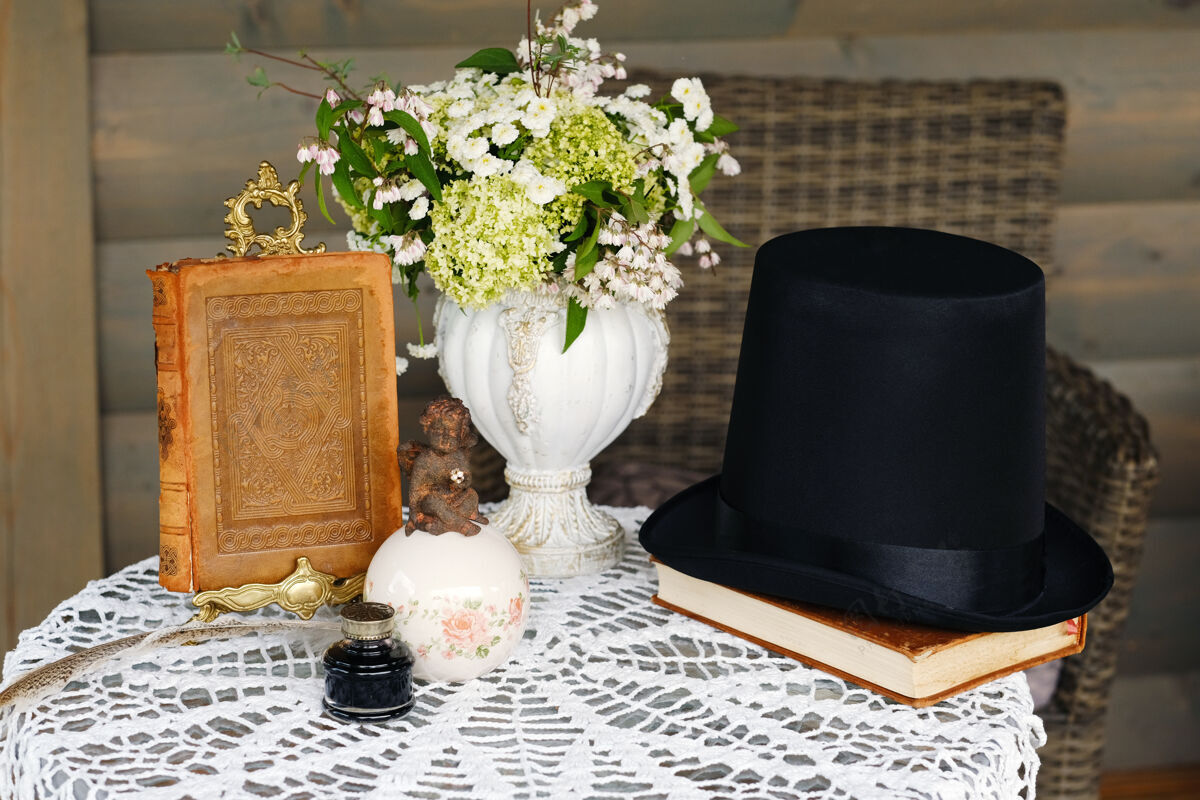 玫瑰桌上装饰着鲜花和一本书 桌上装饰着烛光晚餐书籍装置帽子