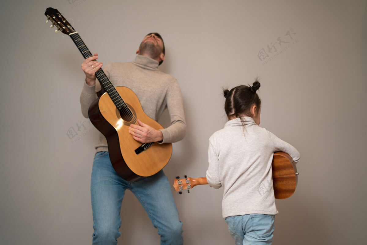 吉他爸爸用手弹吉他女儿孩子学会用钢琴演奏乐器音乐导师父亲和孩子的二重唱二教学快乐