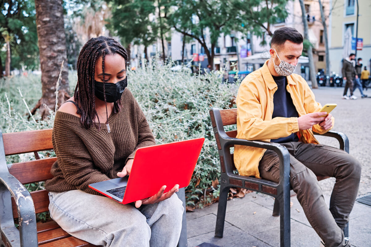 疾病人们戴着口罩 坐在户外保持距离公园新的正常生活方式.城市概念户外口罩社会距离