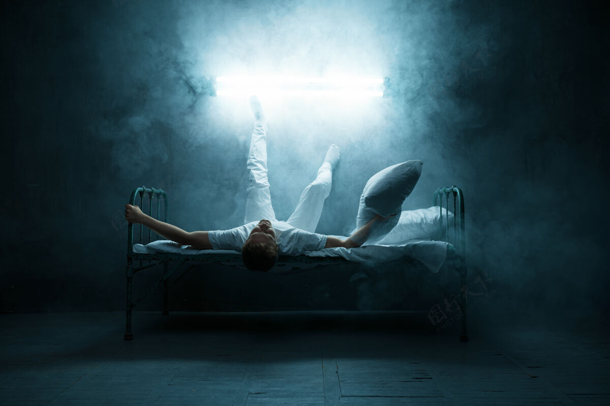 迷幻精神病男人躺在床上 失眠恐怖 黑暗的房间…迷幻的男人每晚都有问题 抑郁和压力 悲伤 精神病医院抑郁家伙疯狂