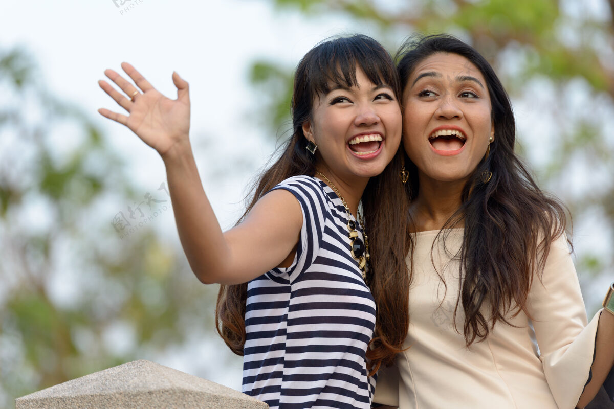 友谊两位亚洲年轻女性在公园户外放松的写真在一起和平女同性恋